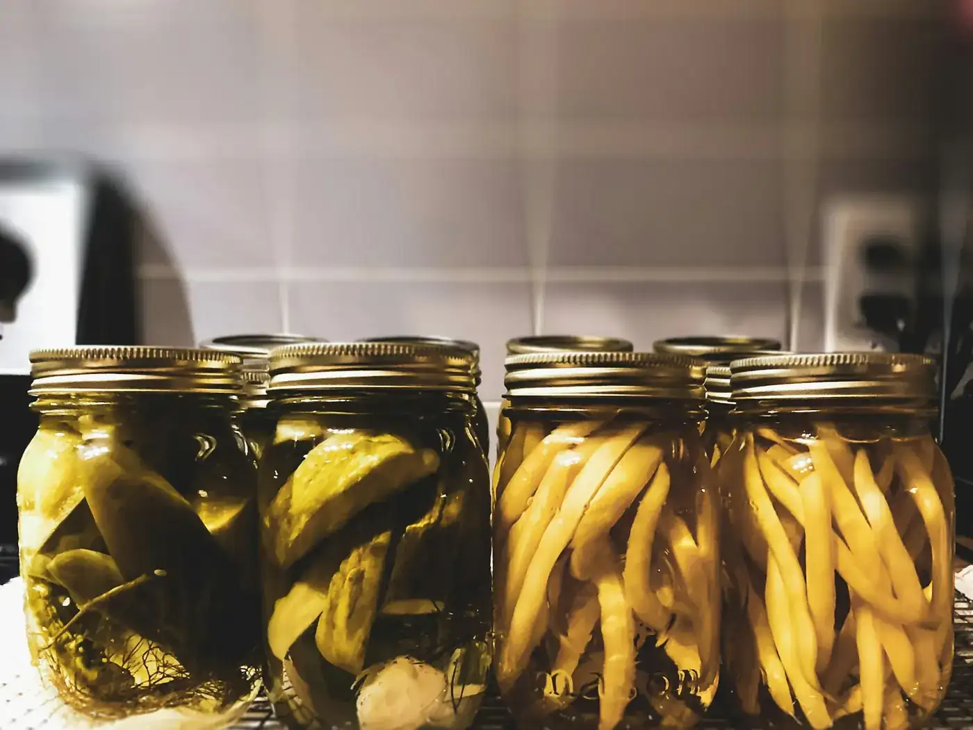 Rows of filled preserving jars on a kitchen rack